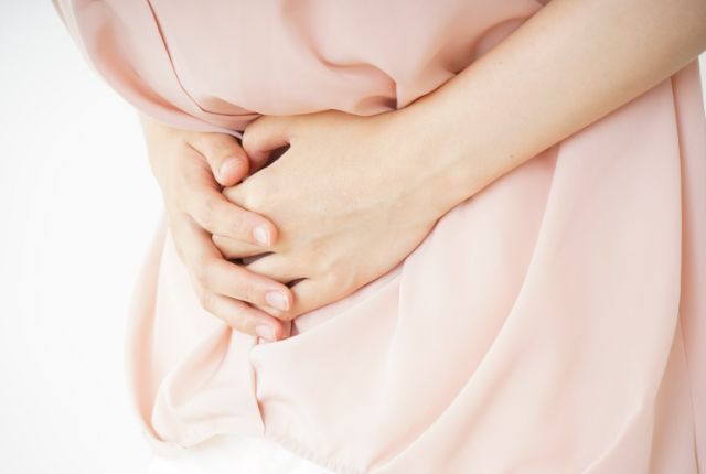 お腹を押さえている女性